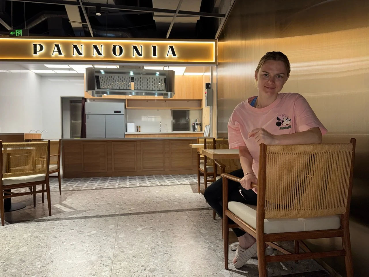 Bianka at PANNONIA, with the café sign and counter behind her